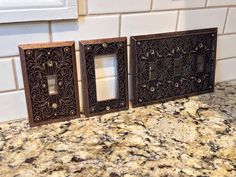 three decorative switch plates on a marble counter top