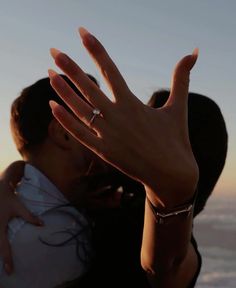 a man and woman kissing with their hands in the air