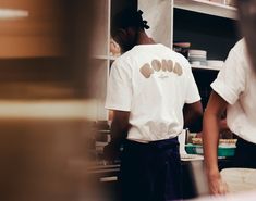 two people working in a kitchen preparing food