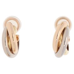 A classic pair of vintage Cartier trinity hoop clip earrings set in 18k yellow, rose and white gold. Each hoop is set in the iconic trinity design and is composed of three 3-millimetre bands, which are soldered together to create the hoop. They are secured to reverse with an omega clip fitting covered by rubber padding. However, a post can be added upon request. Due to their size and design these would make a perfect pair of everyday hoop earrings. For the size reference, the hoops each measure approximately 1.9 centimetres in length and 0.7 centimetres in width. They have a gross weight of 9.3 grams. Each hoop earring is signed and hallmarked on the inside of the hoop Cartier, 750 (for 18k gold), with matching serial number VCQ339. Lastly, this piece is accompanied by the original certifi Clip Earrings, Yellow Rose, Earrings Set, Trinidad, Vintage Cartier, Cartier, Clip On Earrings, Perfect Pair, Earring Set