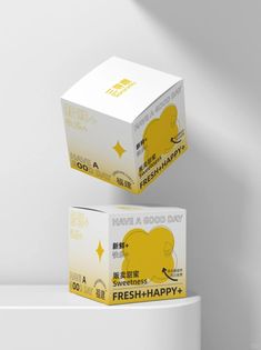 two boxes are stacked on top of each other in front of a white wall with the words fresh - happy