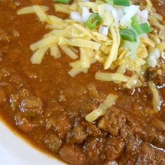 a white plate topped with chili and cheese