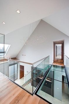 an open floor plan with glass railings and wood floors