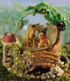 a snow globe with two dogs and a bridge in the middle, surrounded by flowers