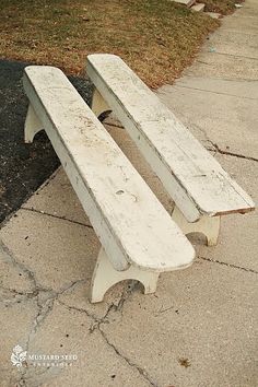 a white bench sitting on the side of a road