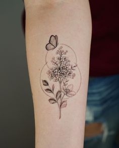 a woman's arm with a flower and butterfly tattoo on it