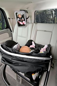 the baby is in the car seat on the back of the vehicle, looking out the window