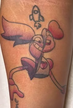 a cartoon character tattoo on the leg of a woman's thigh, with hearts and arrows coming out of it