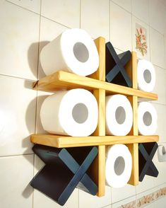 several rolls of toilet paper are stacked on wooden shelves