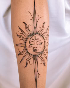 a sun tattoo with a sleeping face on the side of his arm and behind it is an arrow