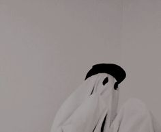 a black and white photo of a person covering their face with a towel in front of them