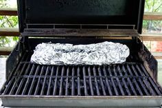 a piece of foil wrapped in aluminum foil sitting on top of an outdoor bbq grill