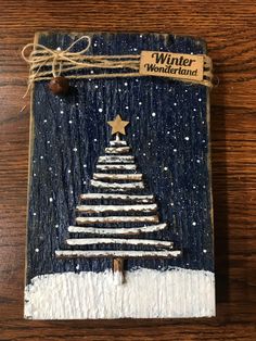 a wooden plaque with a christmas tree painted on it and the words winter wonderland written in gold