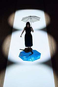 a woman standing on top of an upside down umbrella