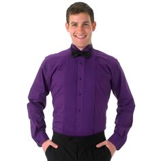 a man in a purple shirt and bow tie posing for the camera with his hands on his hips