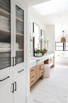 a white bathroom with two sinks and large mirrors