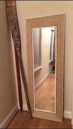 an old baseball bat leaning against the wall in front of a mirror with a wooden stick sticking out of it