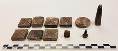 several pieces of wood are displayed on a checkered tablecloth with a ruler and other items