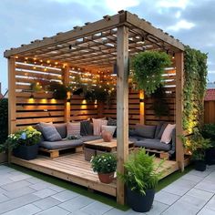 an outdoor living area with couches and potted plants on the side of it