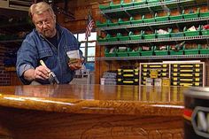 a man standing at a counter holding a paintbrush