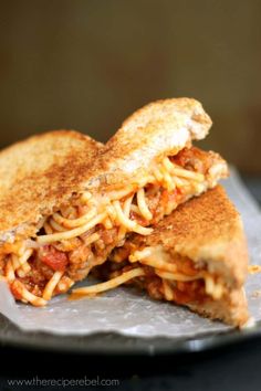 a grilled cheese and tomato sandwich is on a plate, with the rest of the sandwich cut in half