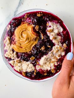 a bowl filled with oatmeal and fruit topped with an orange peanut butter sauce