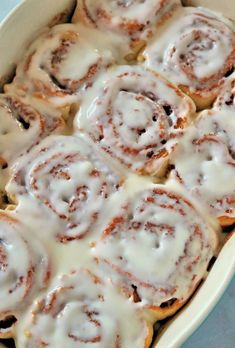 cinnamon rolls with icing in a white dish