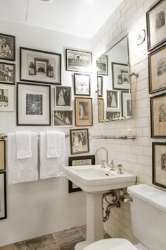 a white bathroom with pictures on the wall