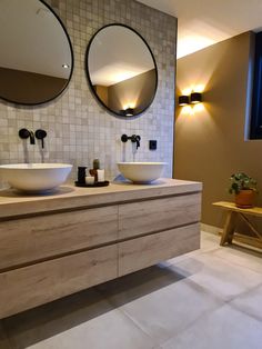 a bathroom with two sinks and mirrors on the wall