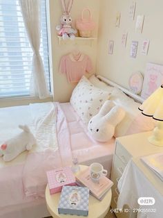 a small child's bedroom with pink bedding and white accessories on the table