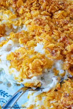 a casserole dish with cheese and other toppings on a blue and white plate