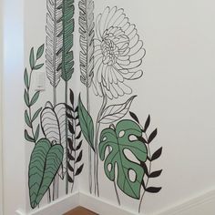 a wall with flowers and leaves painted on it in the corner of a room next to a doorway