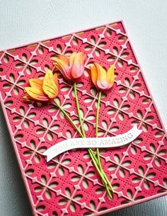 three flowers are placed on top of a card