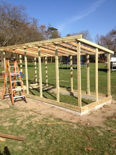 a small wooden structure in the middle of a field with ladders on each side