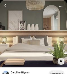 there is a large bed with pillows and blankets on the floor next to a potted plant