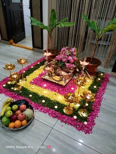 an arrangement of fruits and flowers on the floor