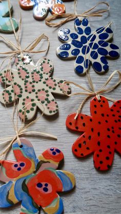 colorful ceramic ornaments hanging from twine on wooden table