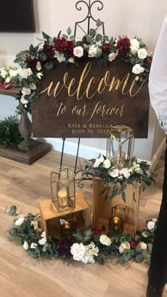 a welcome sign is surrounded by flowers and candles