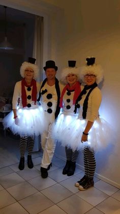 three people dressed in costumes standing next to each other on a tile floor with white walls