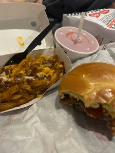 a hamburger and fries are sitting on the table next to each other, with sauce