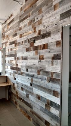 a wooden wall in an office area with a desk and computer on the other side