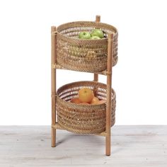 two wicker baskets stacked on top of each other with apples in the bottom basket