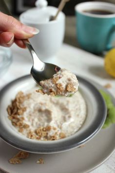 a person is eating oatmeal on a plate with a spoon in their hand