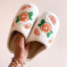 Cozy white fuzzy slippers featuring vibrant embroidered orange slices and green leaves. Perfect for lounging at home, these stylish and comfortable slippers add a playful touch to your indoor footwear collection. Ideal for gifting or personal use. Whether you're lounging around the house or adding a quirky touch to your outfit, our unique slippers with oranges are the ultimate statement piece for fruit lovers and fashion enthusiasts alike. Slippers Photoshoot, Cute Slippers Aesthetic, Aesthetic Slippers, Fruit Shoes, Bday Basket, Slippers Aesthetic, Unique Slippers, Fall Slippers, Collab Ideas