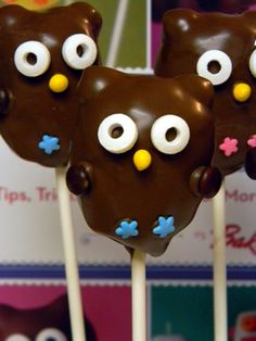 three chocolate owl lollipops with googly eyes on them sitting on top of each other