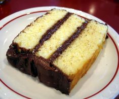 a piece of cake sitting on top of a white plate with red trim around it