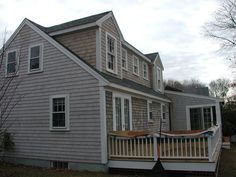 a house with a porch and stairs leading up to the front door on a cloudy day