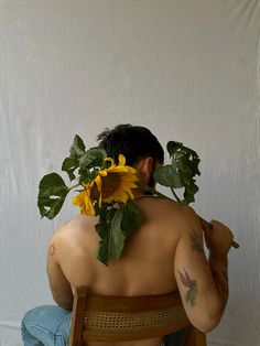 a man sitting in a chair with sunflowers on his back