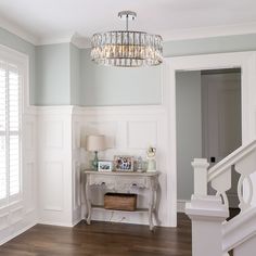 a living room with a chandelier and wooden floors