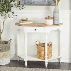 a white table with a basket on it and a potted plant next to it